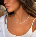 Collier aigue-marine et nacre blanche à cœur doré porté au cou
