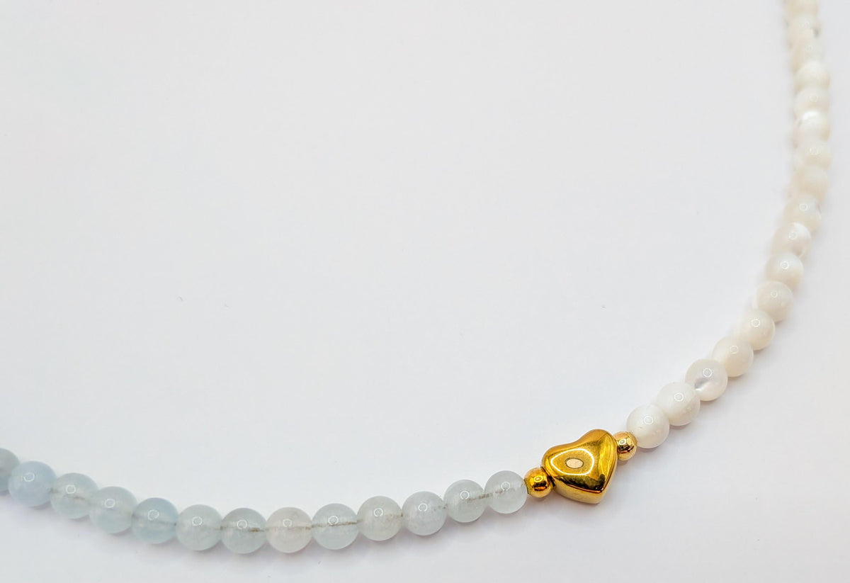 Détail du cœur doré entre les perles d’aigue-marine et de nacre