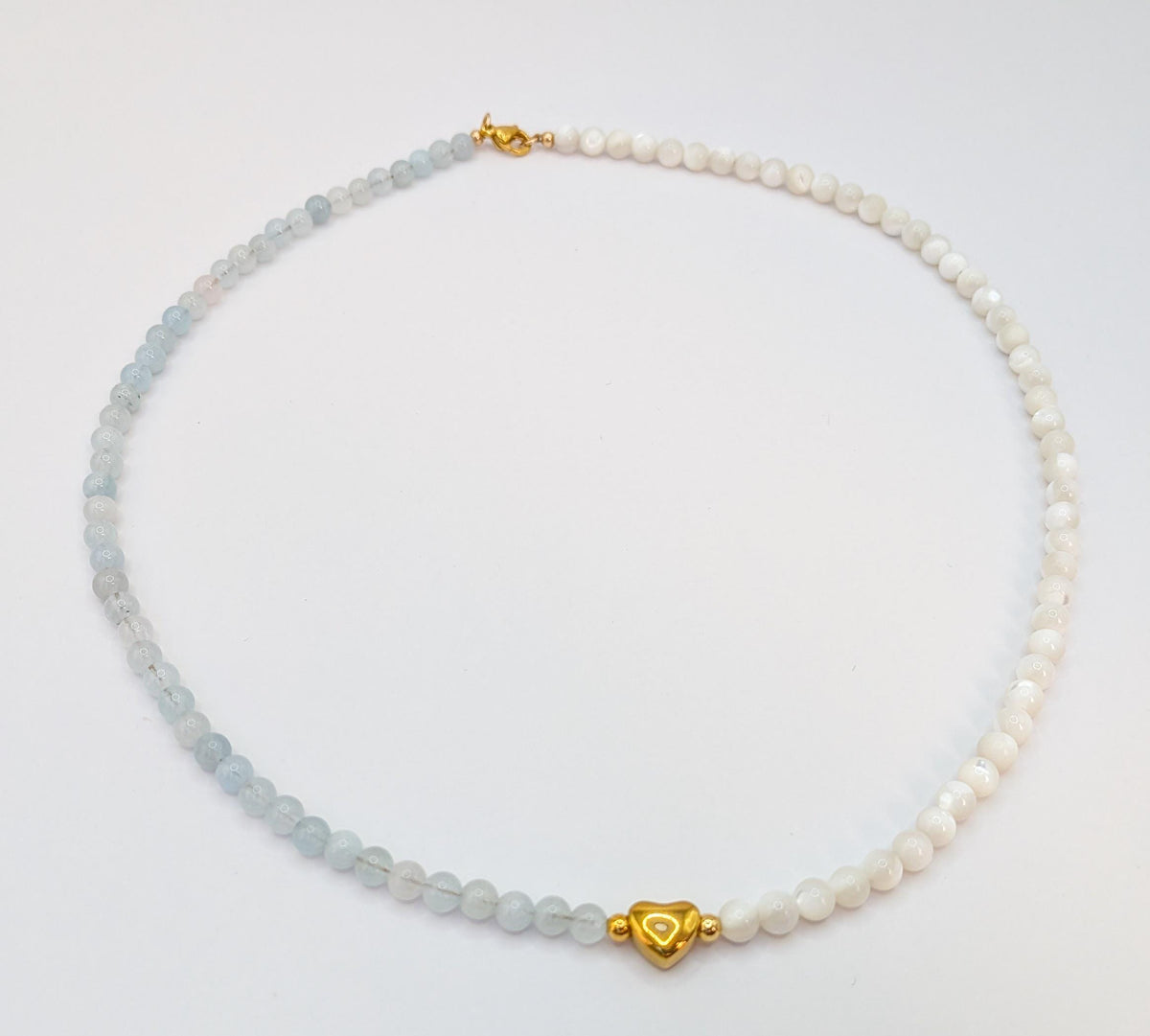 Vue du collier aigue-marine et nacre blanche sur fond blanc