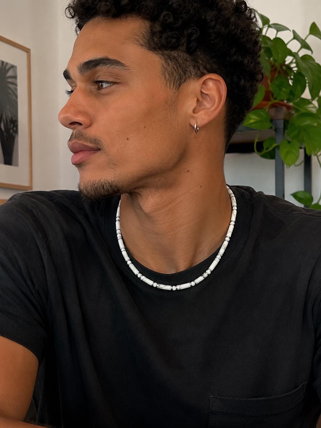 Collier unisexe en howlite blanche et hématite porté avec un tee-shirt noir