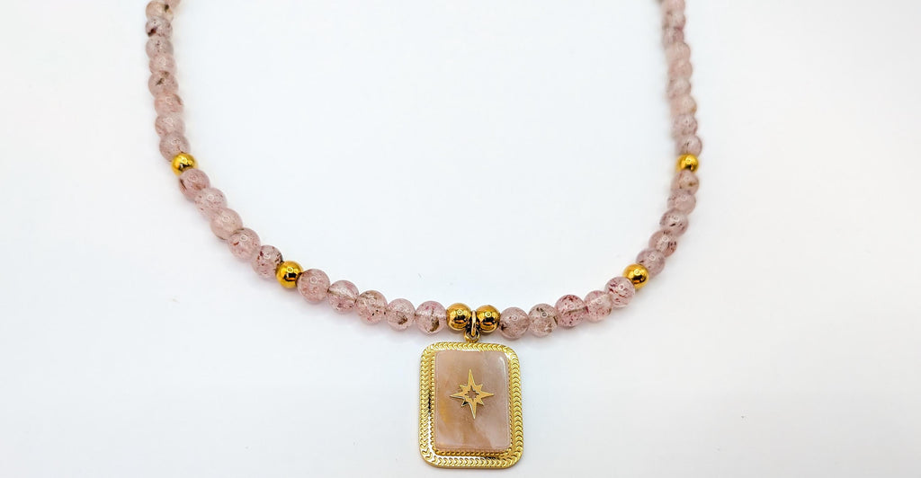 Gros plan du pendentif rectangulaire à étoile dorée et quartz fraise